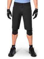 Shorts Alpinestars A-Dura Elite, pantalones cortos negros de mountain bike, usados por un ciclista con guantes negros y rodilleras, con cierre frontal a presión y bolsillos con cremallera, material Cordura duradero para ciclismo de montaña