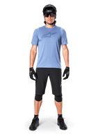 Alpinestars A-Dura Elite Shorts, pantalones cortos de MTB negros, usados con una camiseta azul claro, casco negro, gafas de sol y rodilleras, equipamiento profesional de ciclismo de montaña