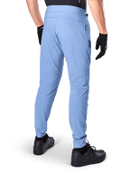 Pantalones Alpinestars A-Dura, pantalones de ciclismo de montaña, color Azul Infinity, vista trasera que muestra el ajuste regular y los puños elásticos, usados con guantes y calzado negros, ropa de ciclismo duradera con tejido elástico en 2 direcciones.