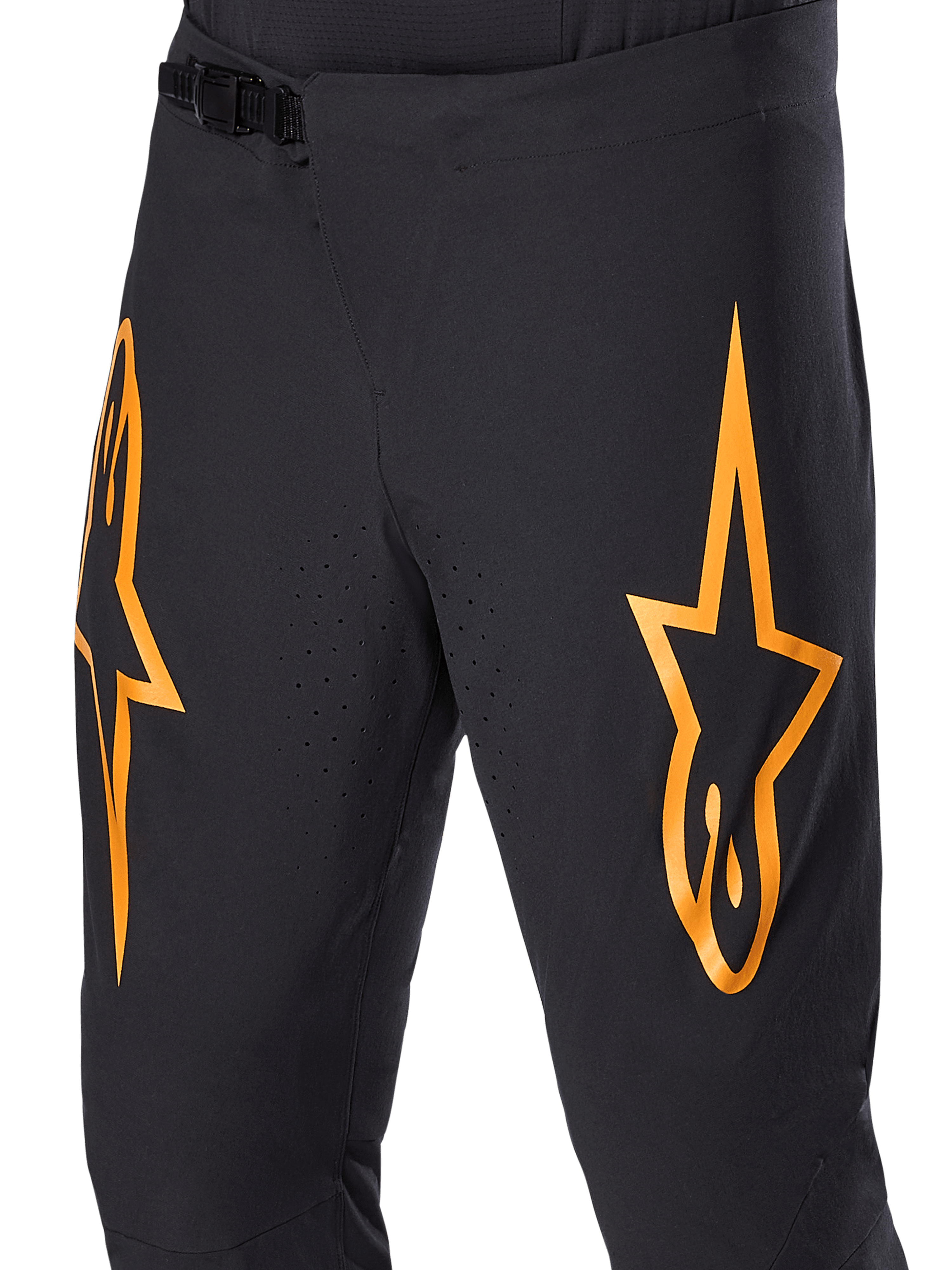 Pantalones Alpinestars A-Supra Race, pantalones de ciclismo MTB negros con grandes logotipos de estrellas naranjas, con cierre de trinquete delantero y orificios de ventilación perforados con láser, diseño técnico de alto rendimiento.