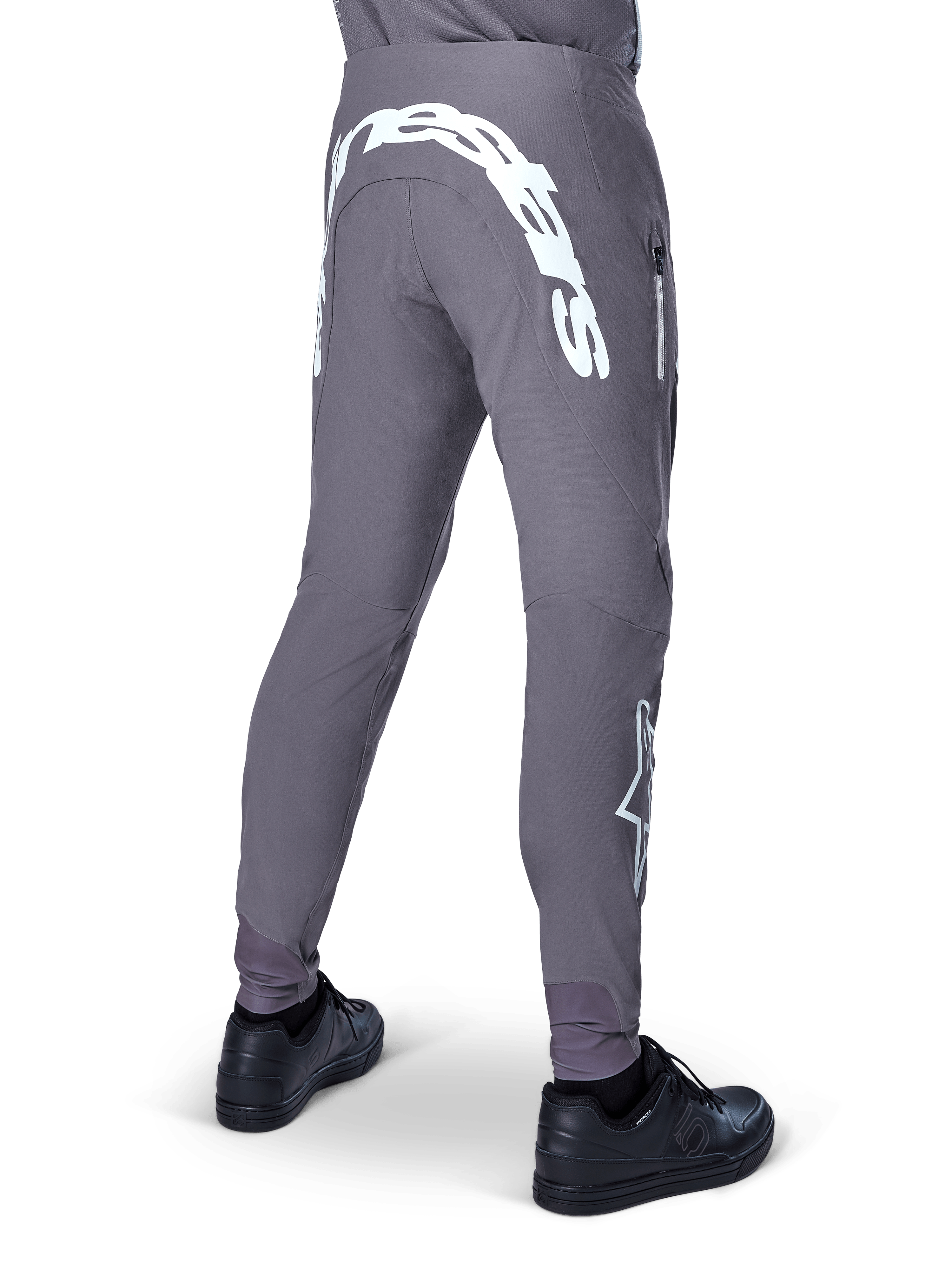 Alpinestars A-Supra Race Pants, Mountain Bike Pants, Dark Gray, rear view worn with black shoes, featuring a large white Alpinestars wordmark on the back yoke and star logo on the leg, zippered pocket, performance stretch fabric for MTB racing