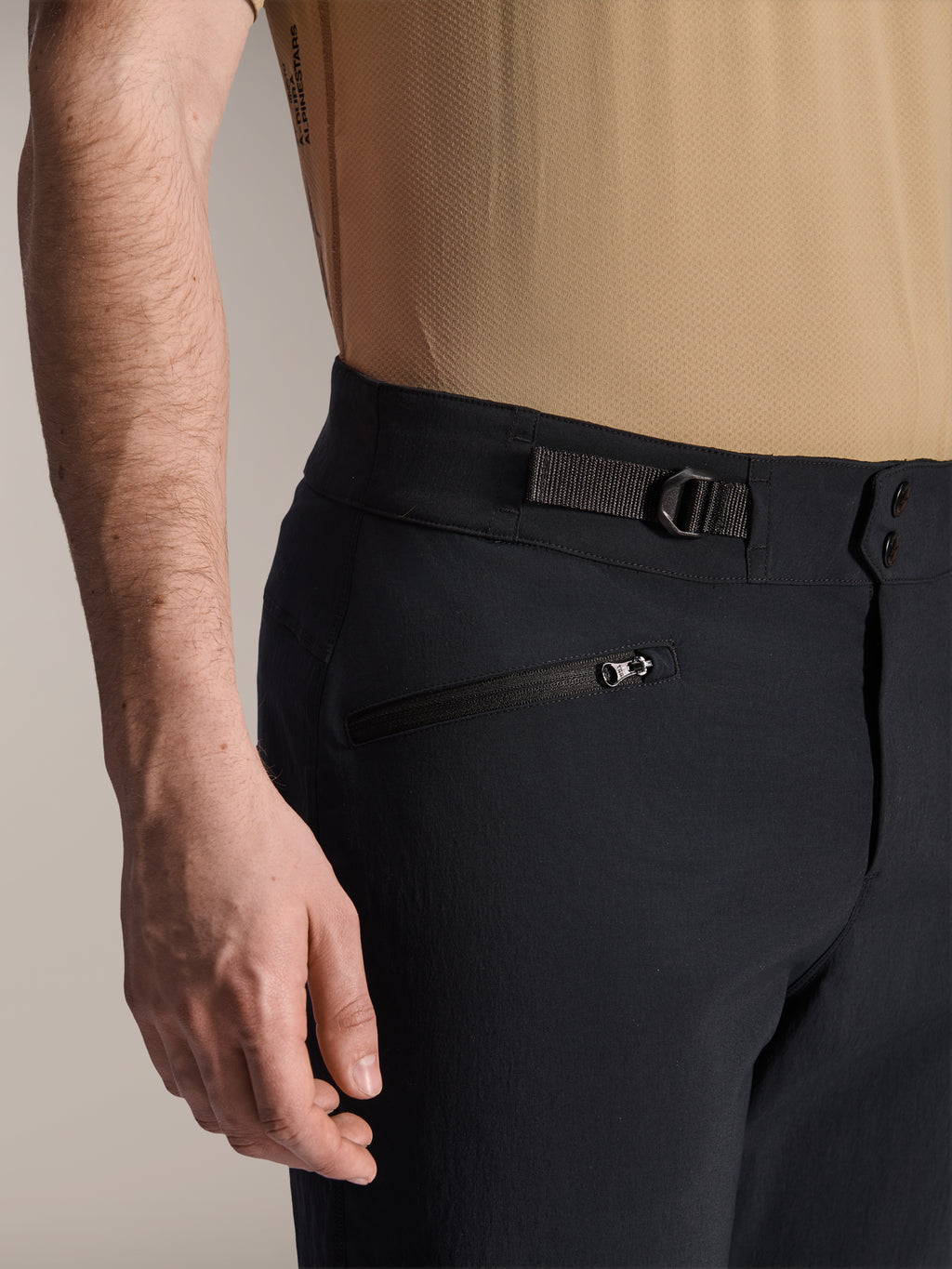 Shorts Alpinestars A-Dura, shorts de MTB negros, vista de cerca que muestra el bolsillo con cremallera y la correa de ajuste lateral, cierre de doble broche, tejido resistente para ciclismo de montaña
