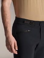Shorts Alpinestars A-Dura, shorts de MTB negros, vista de cerca que muestra el bolsillo con cremallera y la correa de ajuste lateral, cierre de doble broche, tejido resistente para ciclismo de montaña