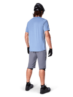 Shorts Alpinestars A-Dura, shorts de MTB en gris oscuro, vista trasera, combinados con un jersey de manga corta azul claro, casco de MTB negro, guantes y calcetines negros con calzado negro, equipamiento funcional y duradero para ciclismo de montaña