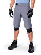 Alpinestars A-Dura Shorts, shorts de ciclismo de montaña gris oscuro, combinados con guantes y rodilleras negros, con bolsillos con cremallera y cierre de doble broche, equipamiento de ciclismo resistente para senderos todoterreno