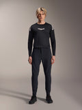 Alpinestars A-Aria Elite Pants, pantalones de MTB Black Titanium, usados por un modelo masculino con un jersey de manga larga negro a juego y zapatillas, diseño de rendimiento con ajuste slim y cierre de hebilla magnética, ropa técnica para bicicleta de montaña