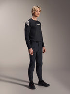 Modelo masculino con pantalones Alpinestars A-Aria Elite en Black Titanium y jersey Aria Polartec Elite LS, equipo de alto rendimiento para bicicleta de montaña en negro, con ventilación perforada por láser y cierre de hebilla magnética en los pantalones, jersey de manga larga con logotipos blancos, conjunto completo de ciclismo todoterreno