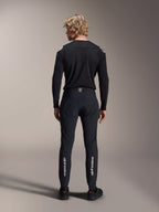 Jersey de manga larga Alpinestars A-Aria Polartec Elite, jersey de MTB negro, vista trasera usado con pantalones negros a juego, ajuste de rendimiento para ciclismo de montaña, con tejido técnico que absorbe la humedad y marca sutil en la parte inferior de la espalda