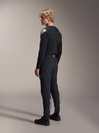 Alpinestars A-Aria Polartec Elite Jersey - Manga Larga, negro, visto desde un perfil lateral posterior, con un logotipo blanco en el hombro, combinado con pantalones de ciclismo negros a juego para un conjunto profesional de MTB.