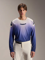 Alpinestars A-Aria Polartec Maker Elite Jersey, jersey de MTB de manga larga, color Baja Blue con degradado de blanco a azul, usado por un modelo con pantalones blancos, con logotipo azul oscuro en el pecho y perforaciones láser en las mangas, ropa de ciclismo de montaña de alto rendimiento