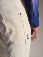 Alpinestars A-Aria Elite Pants, pantalones de alto rendimiento en color crudo, primer plano del bolsillo lateral con cremallera y perforaciones láser para ventilación, detalle de logotipo minimalista, tejido de alta elasticidad para ciclismo de montaña