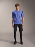 Alpinestars A-Aria Lite Short, pantalones cortos de ciclismo de montaña para hombre, negros, usados con jersey de manga corta morado claro y rodilleras negras, ropa técnica de MTB para alto rendimiento