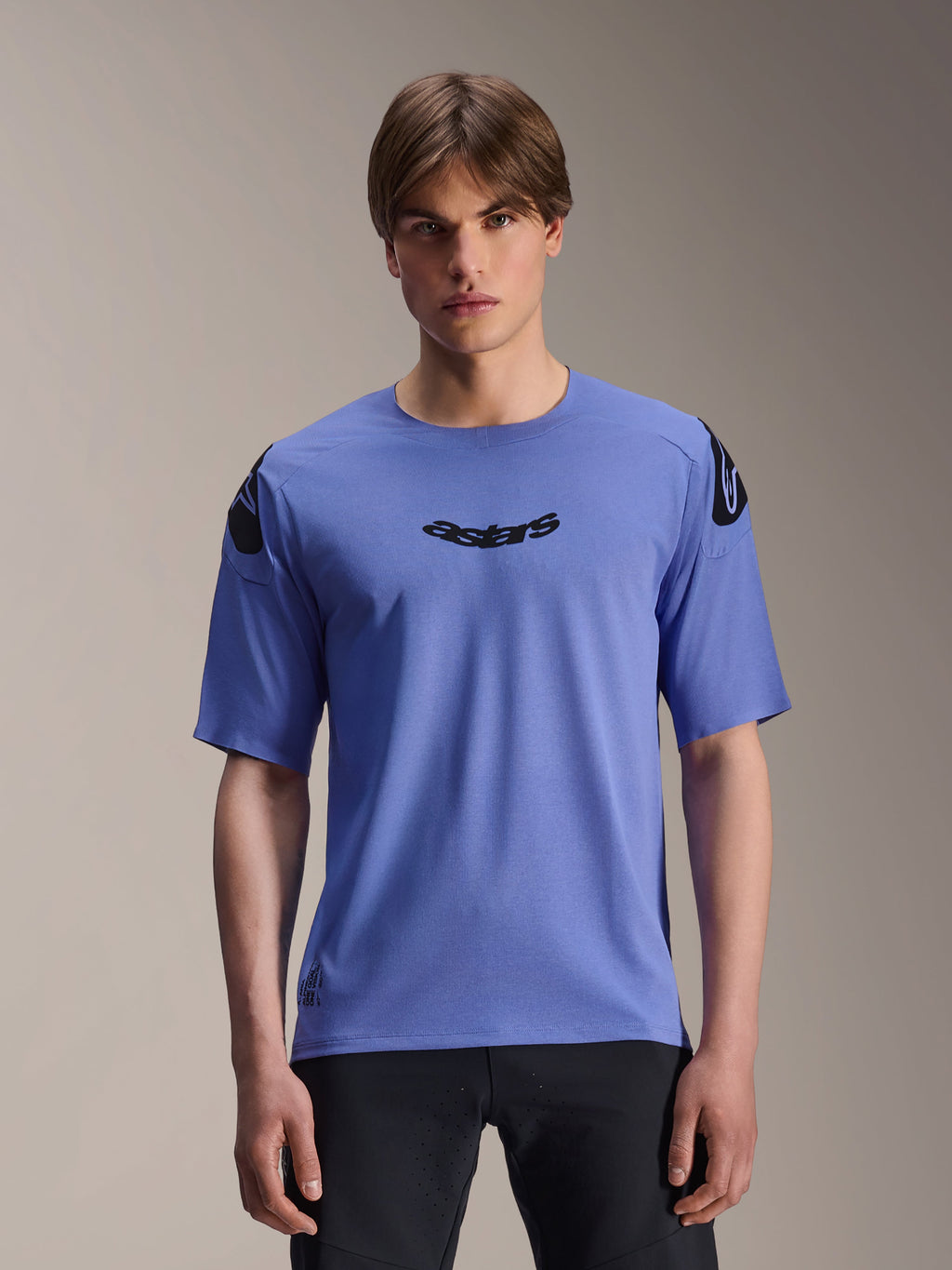 Alpinestars A-Aria Polartec Elite Jersey, camiseta de manga corta para MTB, color azul Baja, usada por un modelo masculino, con el logotipo 'astars' negro en el pecho y logotipos en los hombros, ropa técnica de alto rendimiento para trail.