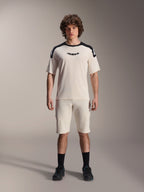 Alpinestars A-Aria Elite Shorts, pantalones cortos de mountain bike, color crudo, combinados con camiseta de manga corta a juego con paneles negros en los hombros y logotipo, look deportivo casual con perforaciones frontales, ropa técnica de alto rendimiento para MTB