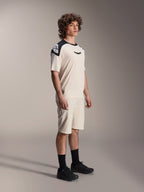 Alpinestars A-Aria Polartec Elite Short Sleeve Jersey, color crudo con paneles negros en los hombros y logotipo, vestida por un modelo con pantalones cortos a juego y calzado negro, ropa de alto rendimiento para ciclismo de montaña y rutas por senderos.