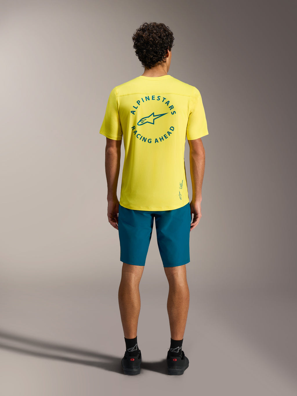 Jersey A-Dura Air SS amarillo con logo verde azulado y shorts A-Dura Ride azul verde, equipamiento profesional MTB.