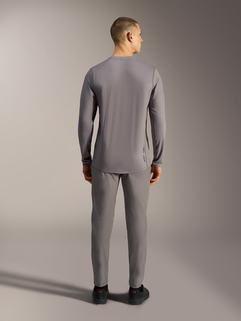Camiseta Alpinestars A-Dura Ride gris de manga larga para MTB, tejido elástico jacquard y corte trasero más largo.