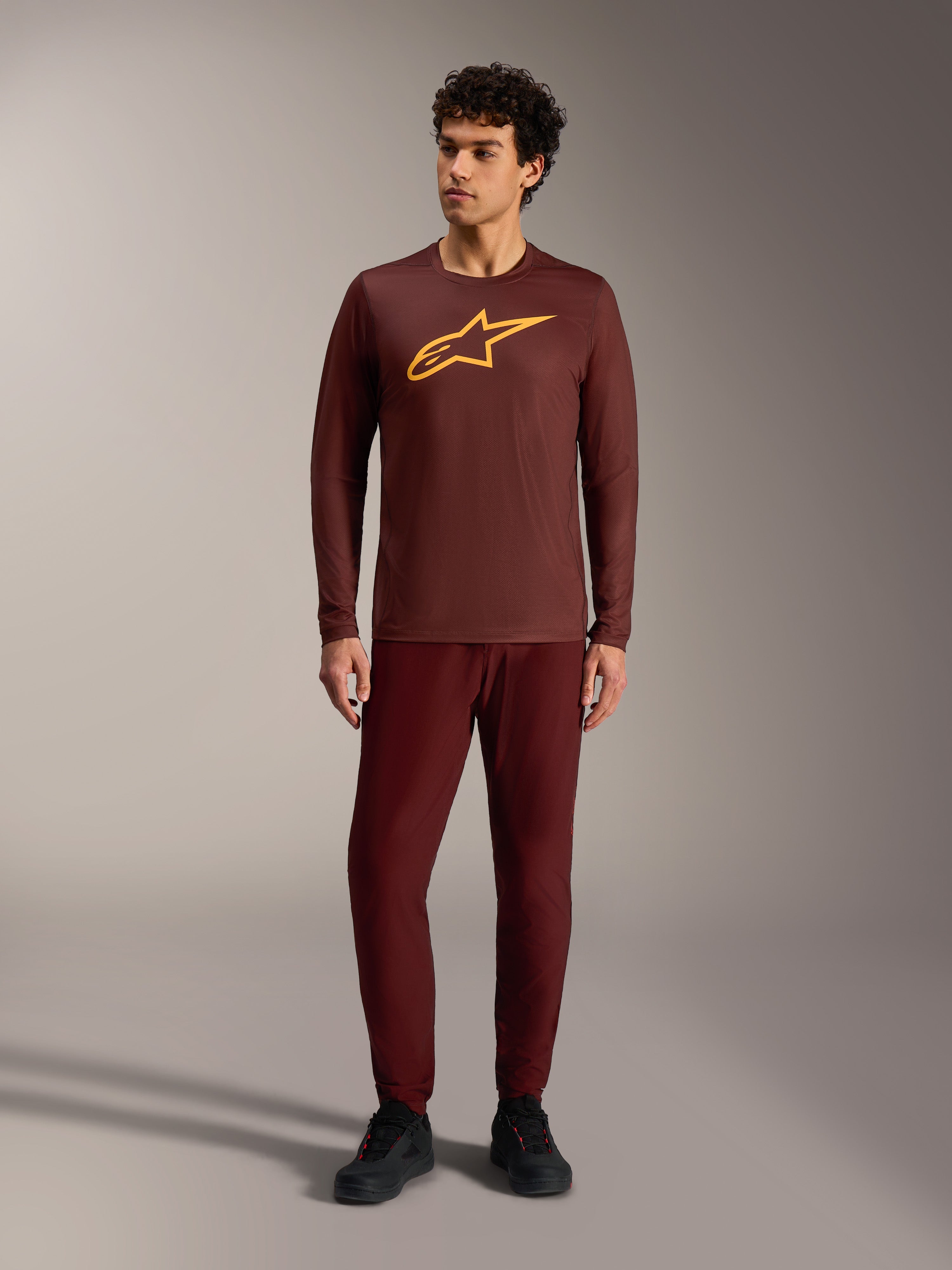 Camiseta A-Dura Ride de manga larga burdeos con logo Alpinestars amarillo y pantalones a juego para trail MTB.