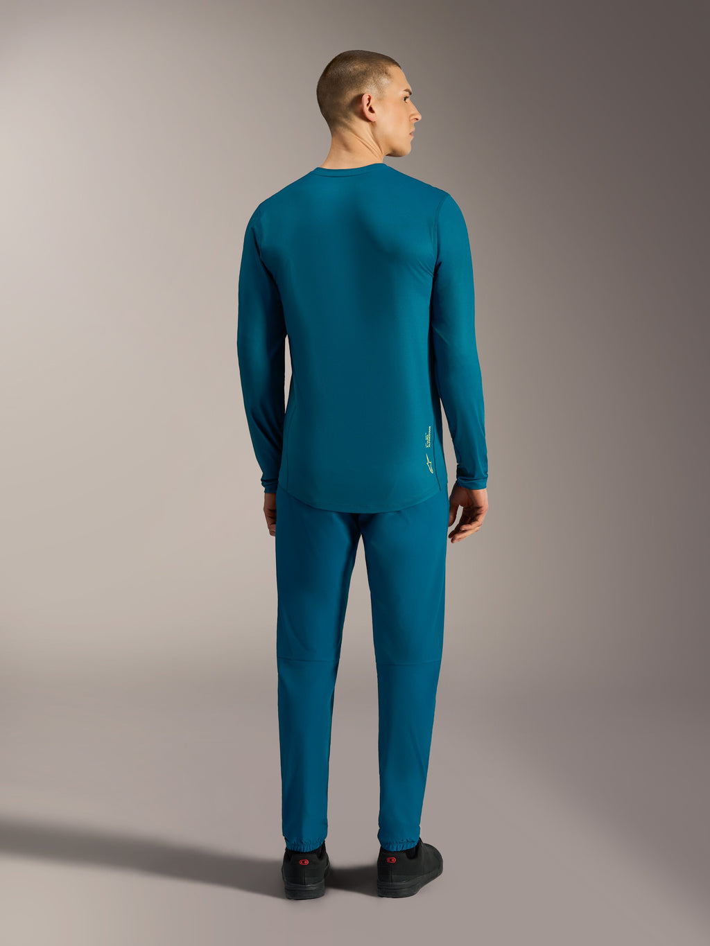 Jersey A-Dura Ride azul verde, vista trasera con cola extendida para rendimiento en ciclismo de montaña.