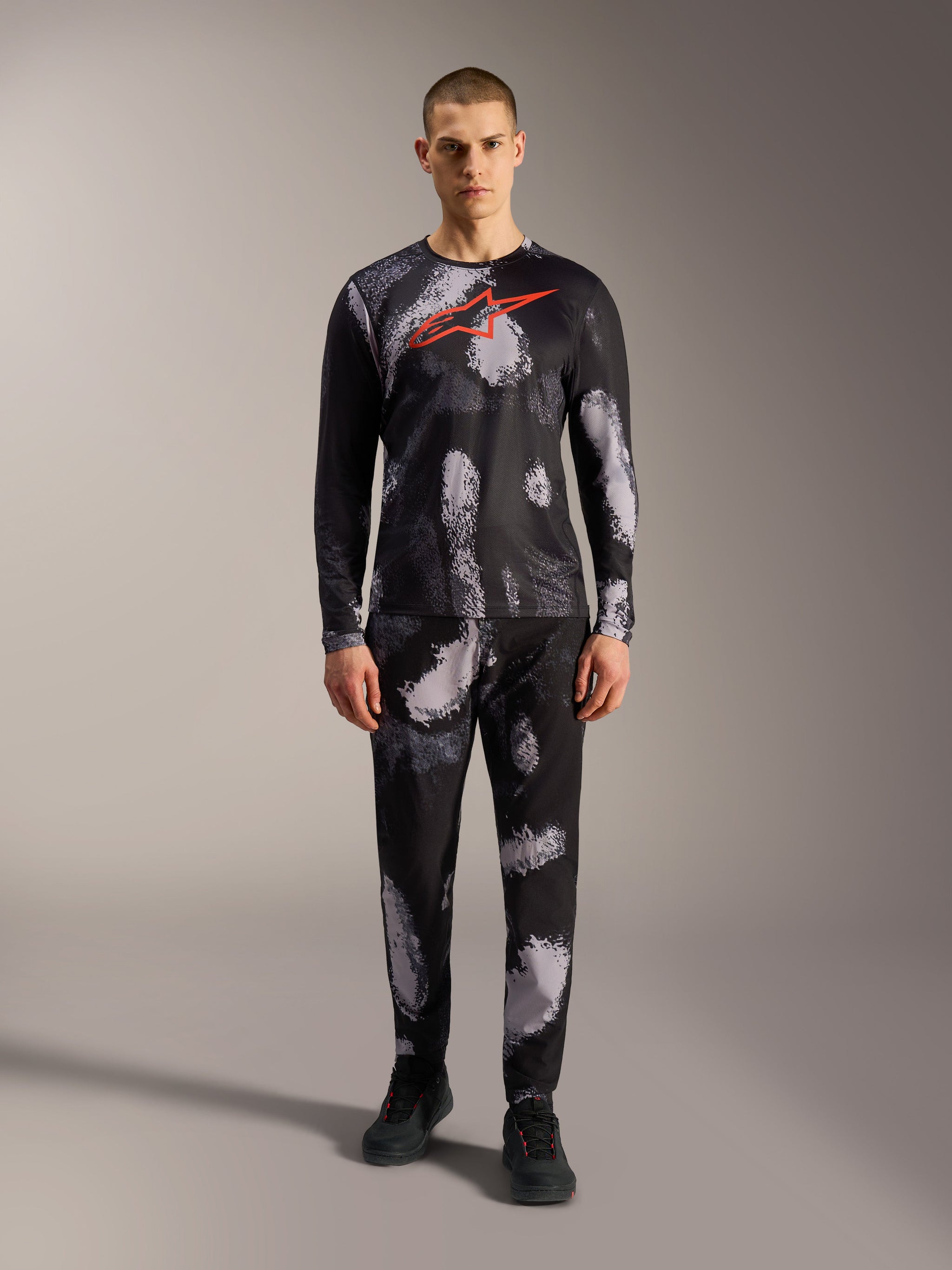 Camiseta A-Dura Ride manga larga, camuflaje negro con logo Astars rojo y pantalones a juego, estilo MTB de alto rendimiento.