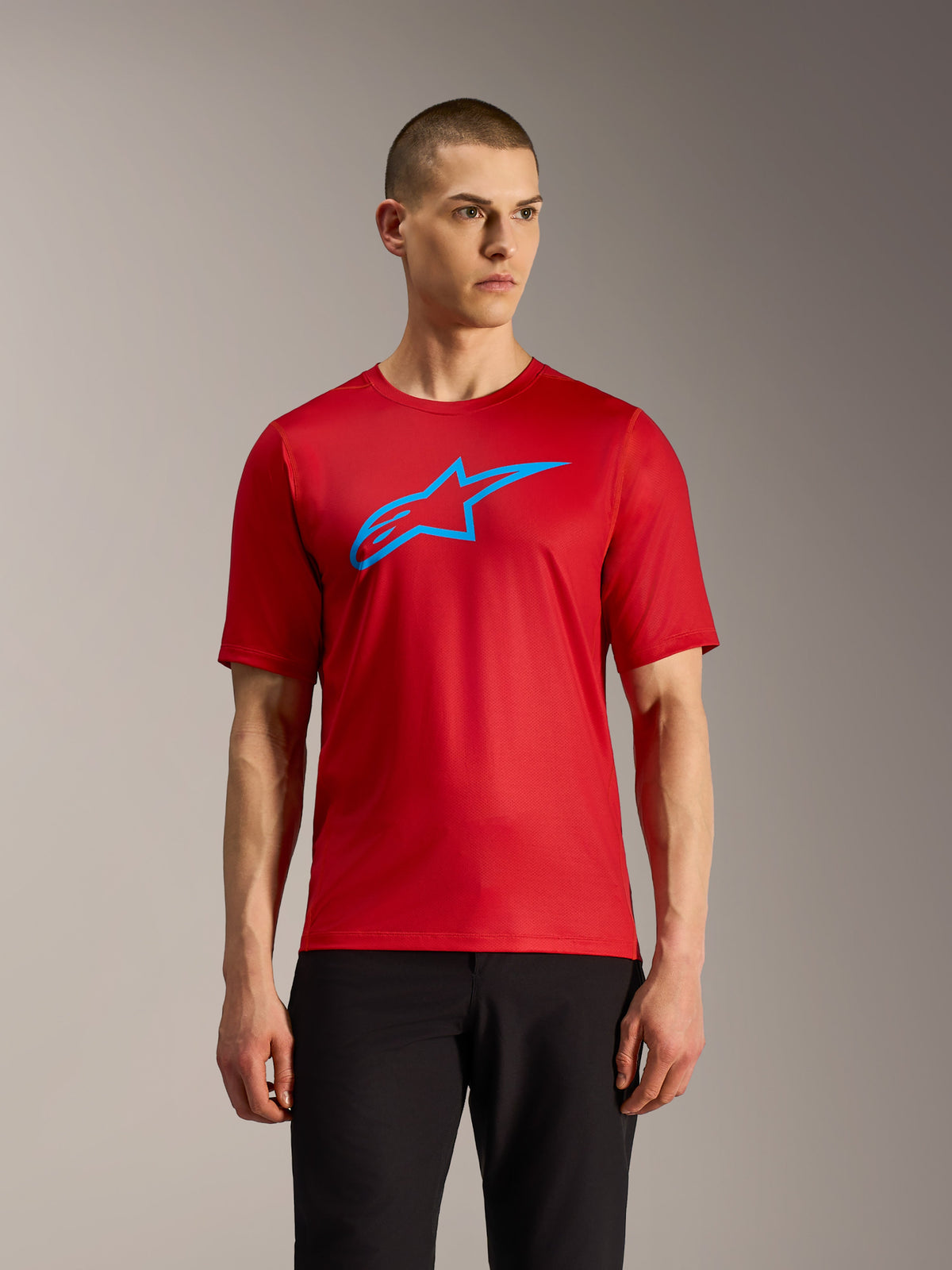 Camiseta A-Dura Ride roja de manga corta con logotipo Alpinestars azul, prenda ligera técnica para ciclismo de montaña.