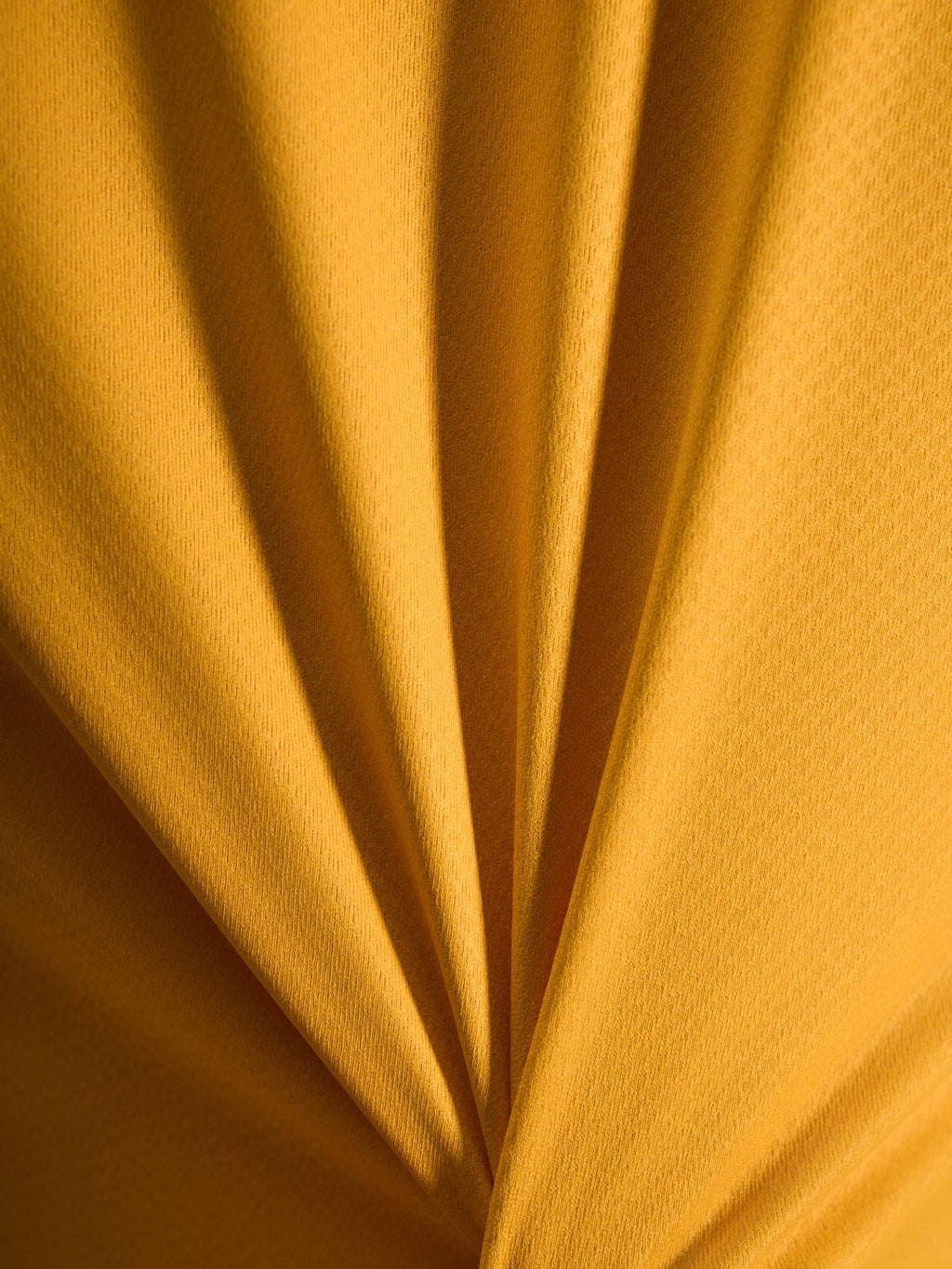 Primer plano de la textura naranja del jersey A-Dura Ride, tejido jacquard ligero de poliéster y spandex.