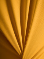 Primer plano de la textura naranja del jersey A-Dura Ride, tejido jacquard ligero de poliéster y spandex.