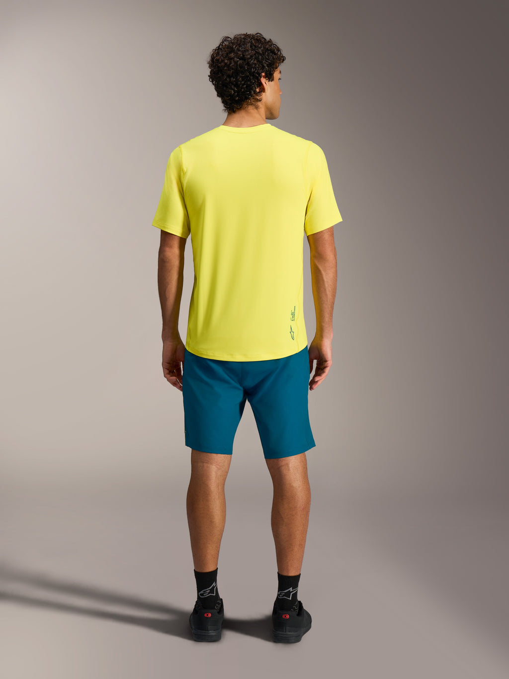 Jersey A-Dura Ride SS amarillo y shorts A-Dura Ride azul verdoso, vista trasera de ropa técnica para MTB.