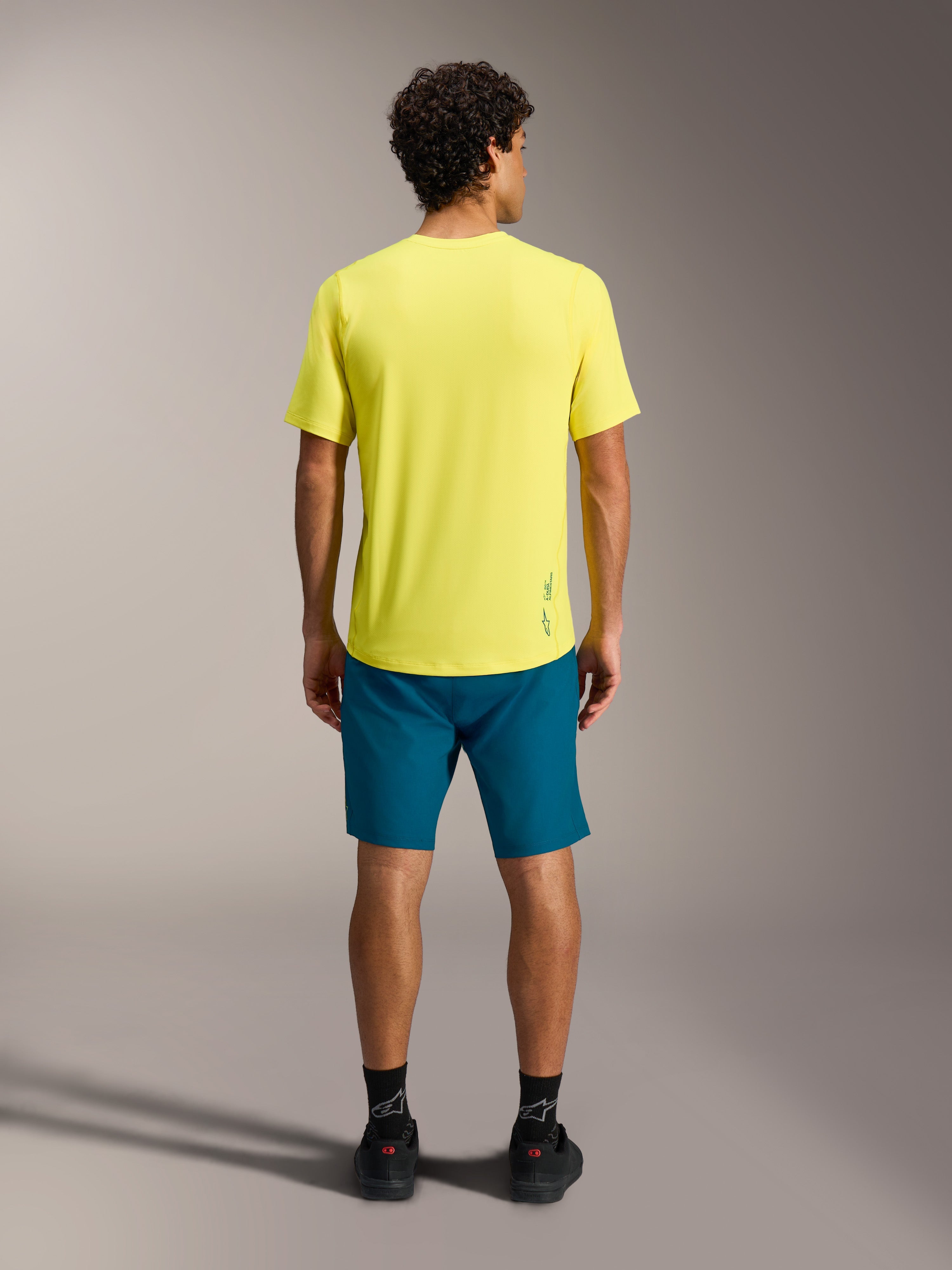 Jersey A-Dura Ride SS amarillo y shorts A-Dura Ride azul verdoso, vista trasera de ropa técnica para MTB.