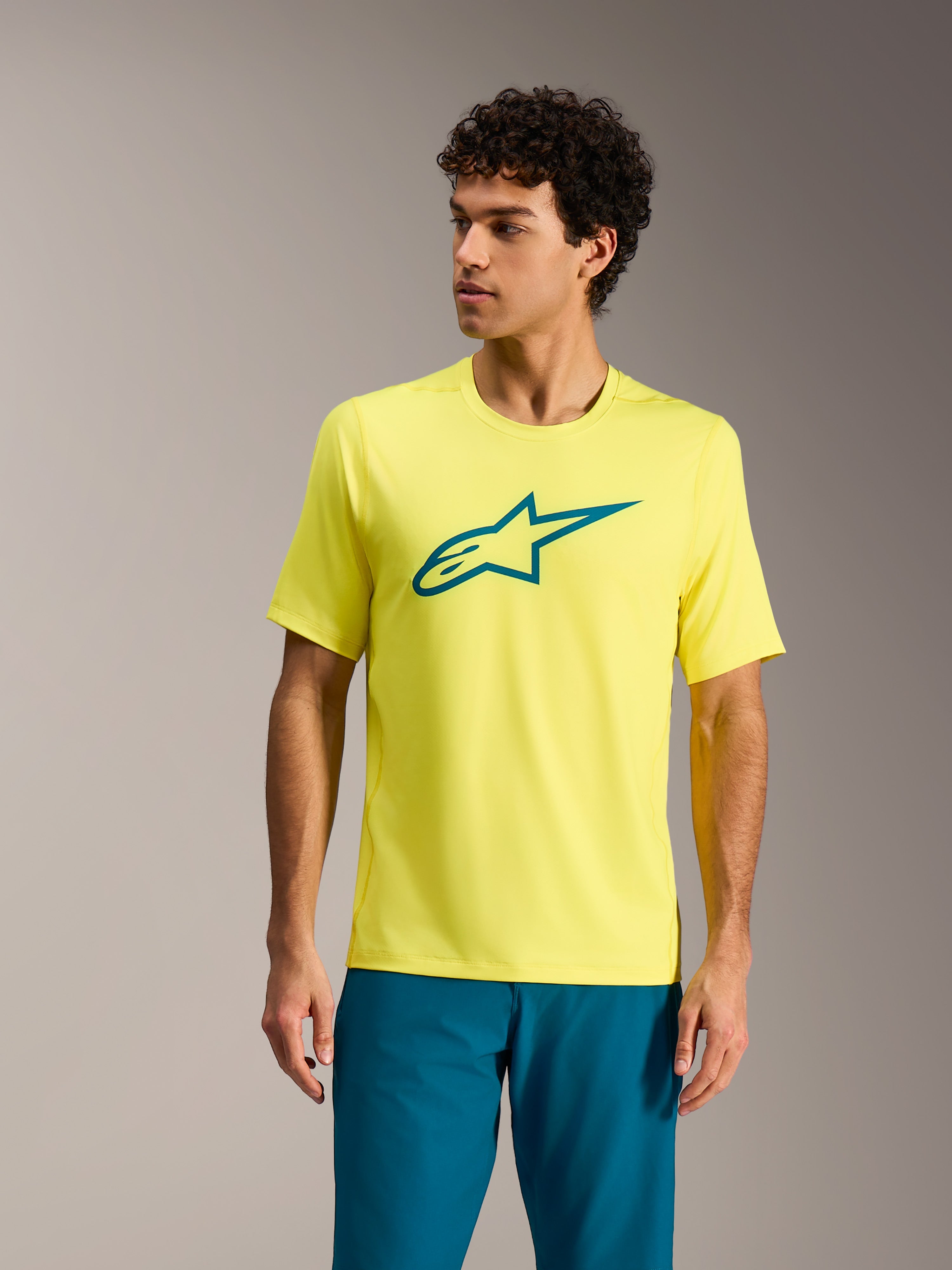 Camiseta Alpinestars A-Dura Ride amarillo flúor, top de MTB de manga corta con logotipo Astars verde azulado.