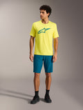 Jersey Alpinestars A-Dura Ride SS amarillo y pantalones cortos verde azulado, ropa técnica de MTB en estudio.
