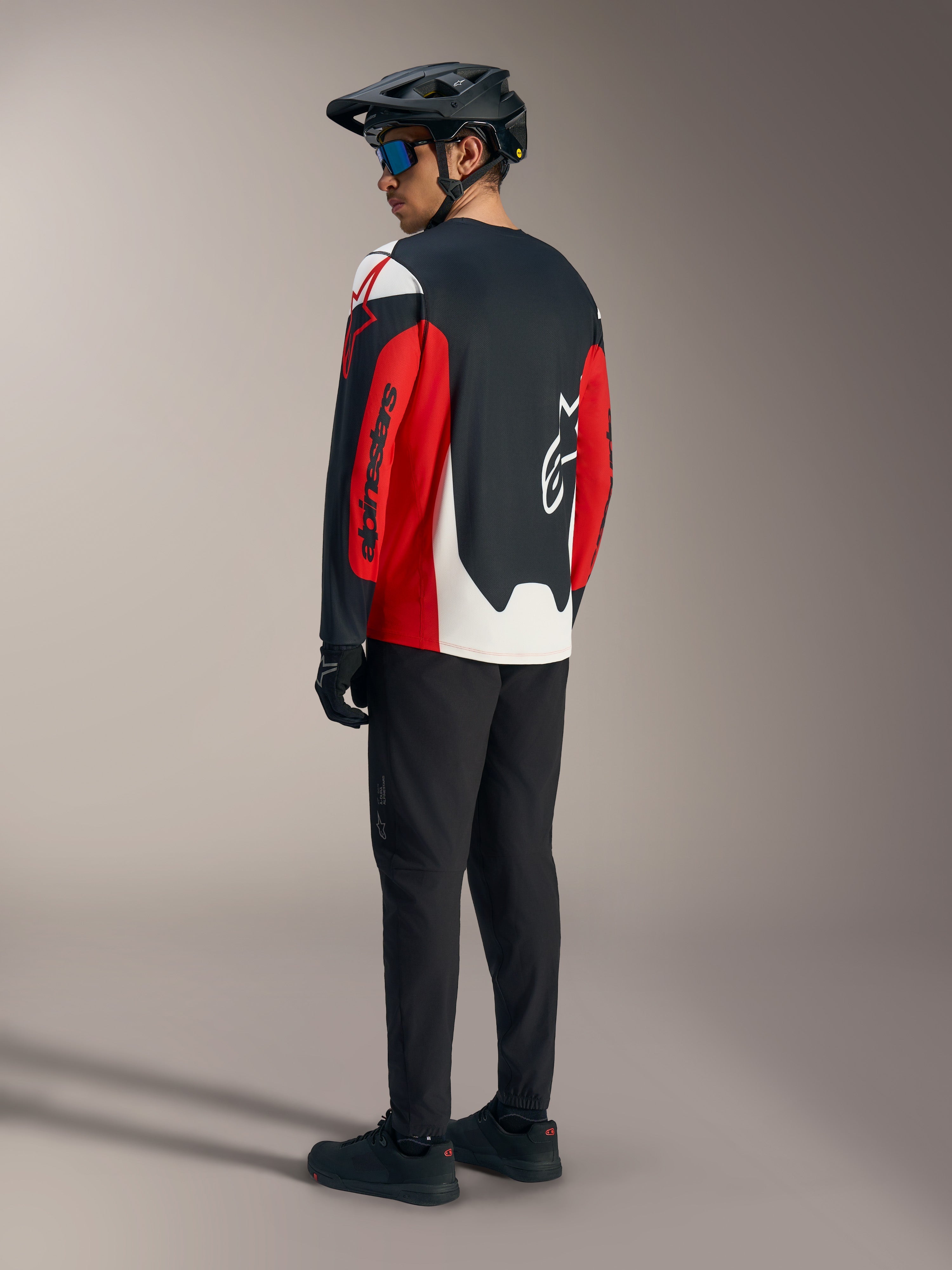 Jersey Alpinestars A-Dura Race rojo de manga larga con gráficos llamativos, vista trasera en conjunto de MTB.