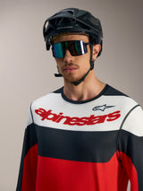 Jersey Alpinestars A-Dura Race rojo, blanco y negro con logo, casco de MTB negro y gafas, diseño técnico para montaña.