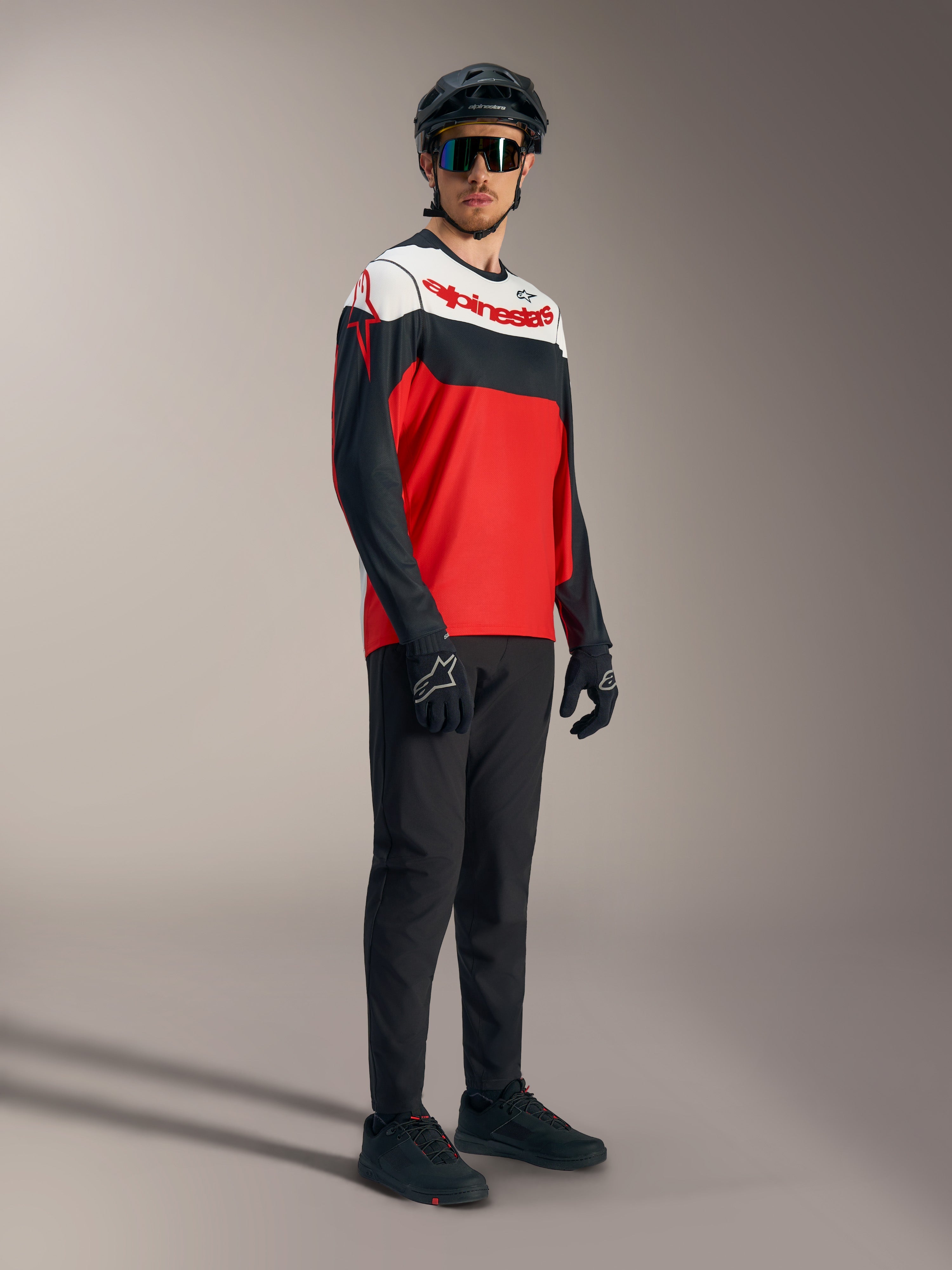 Camiseta Alpinestars A-Dura Race roja, negra y blanca de manga larga con logos, y equipación profesional de MTB.
