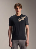 Modelo masculino con jersey de manga corta Alpinestars A-Dura Lipan, jersey de MTB negro con logo de estrella beige y mangas gris oscuro, combinado con pantalones de ciclismo grises, indumentaria de rendimiento casual