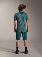 Jersey de manga corta Alpinestars A-Dura Lipan en Silver Pine, vista trasera que muestra los paneles de jacquard texturizado en los hombros y el dobladillo con cola más larga, usado con pantalones cortos de MTB verde oscuro a juego y calzado negro