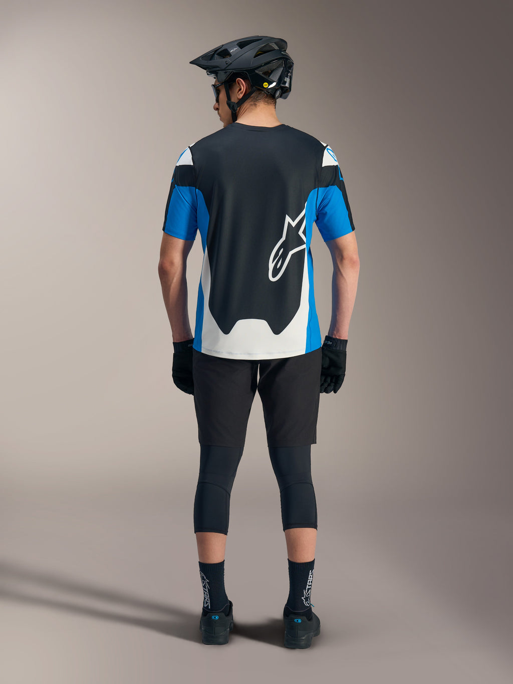 Jersey Alpinestars A-Dura Race SS azul y negro, con pantalones cortos técnicos de MTB y equipo de alto rendimiento.
