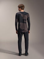 Alpinestars A-Dura Hollow Camo Jersey de manga larga, Black Camo, vista trasera con pantalones negros, con un patrón de camuflaje oscuro y dobladillo trasero más largo para cobertura de MTB.