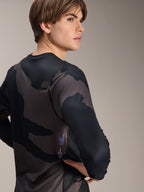 Alpinestars A-Dura Hollow Camo Long Sleeve Jersey, Black Camo, modelo masculino visto desde atrás, con un patrón de camuflaje oscuro y marca serigrafiada en la parte inferior de la espalda, camiseta técnica de MTB de manga larga