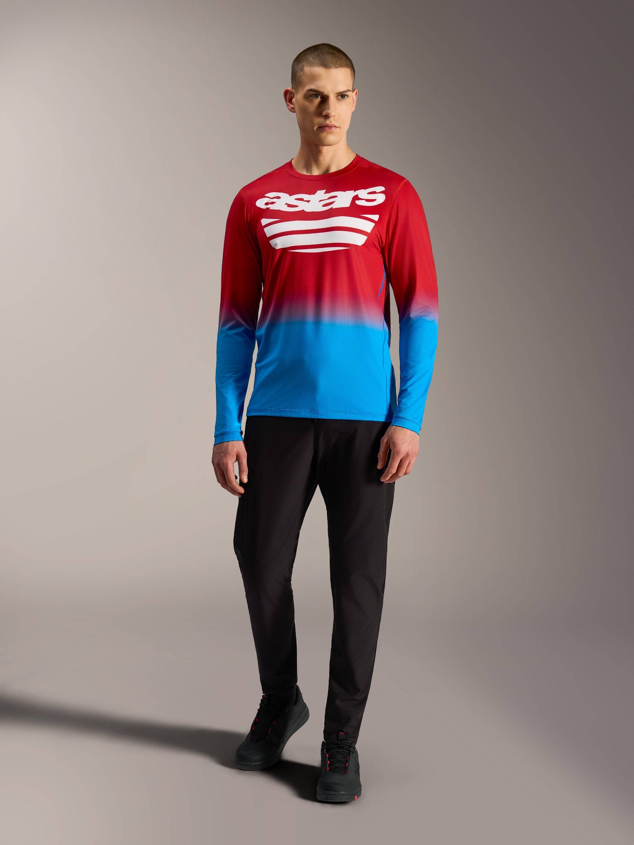 A-Dura ASTARS 2.0 Long Sleeve MTB Jersey in Bright Red Blue gradient with white logos, modeled with black pants.