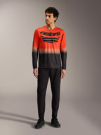 Camiseta A-Dura ASTARS 2.0 de manga larga, degradado naranja y negro con logo en el pecho y pantalones de MTB negros.