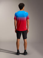 Maillot A-Dura ASTARS 2.0 de manga corta, degradado azul y rojo, vista trasera con shorts negros para ciclismo de montaña.
