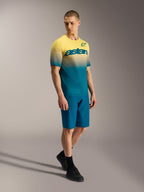 Maillot de MTB A-Dura ASTARS 2.0 con degradado amarillo a azul, manga corta y logo en el pecho sobre un modelo.