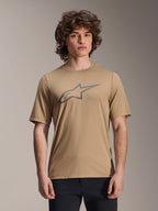 Alpinestars A-Dura Astar Short Sleeve Jersey, marrón claro, usado por un modelo masculino con pantalones negros, logotipo de estrella Alpinestars en gris en el pecho, jersey casual de ciclismo de montaña para trail