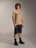 Shorts Alpinestars A-Dura, shorts de ciclismo de montaña negros, usados por un modelo con un jersey de manga corta color tostado con el logo de Alpinestars, calcetines negros y zapatillas negras, equipamiento de MTB duradero para conducción todoterreno