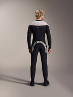 Pantalones Alpinestars A-Supra Melt, negros, vista trasera que muestra el gran logotipo de Alpinestars en blanco en el canesú trasero, combinados con un jersey de manga larga a juego y zapatillas de ciclismo negras, equipamiento de alto rendimiento para bicicleta de montaña en rutas fuera de pista.