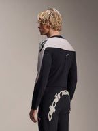 Modelo masculino con jersey de manga larga Alpinestars A-Supra Melt y pantalones A-Supra Melt, conjunto de carreras de MTB negro y gris claro, con el logotipo de Alpinestars en blanco grande y llamativo en el canesú trasero de los pantalones