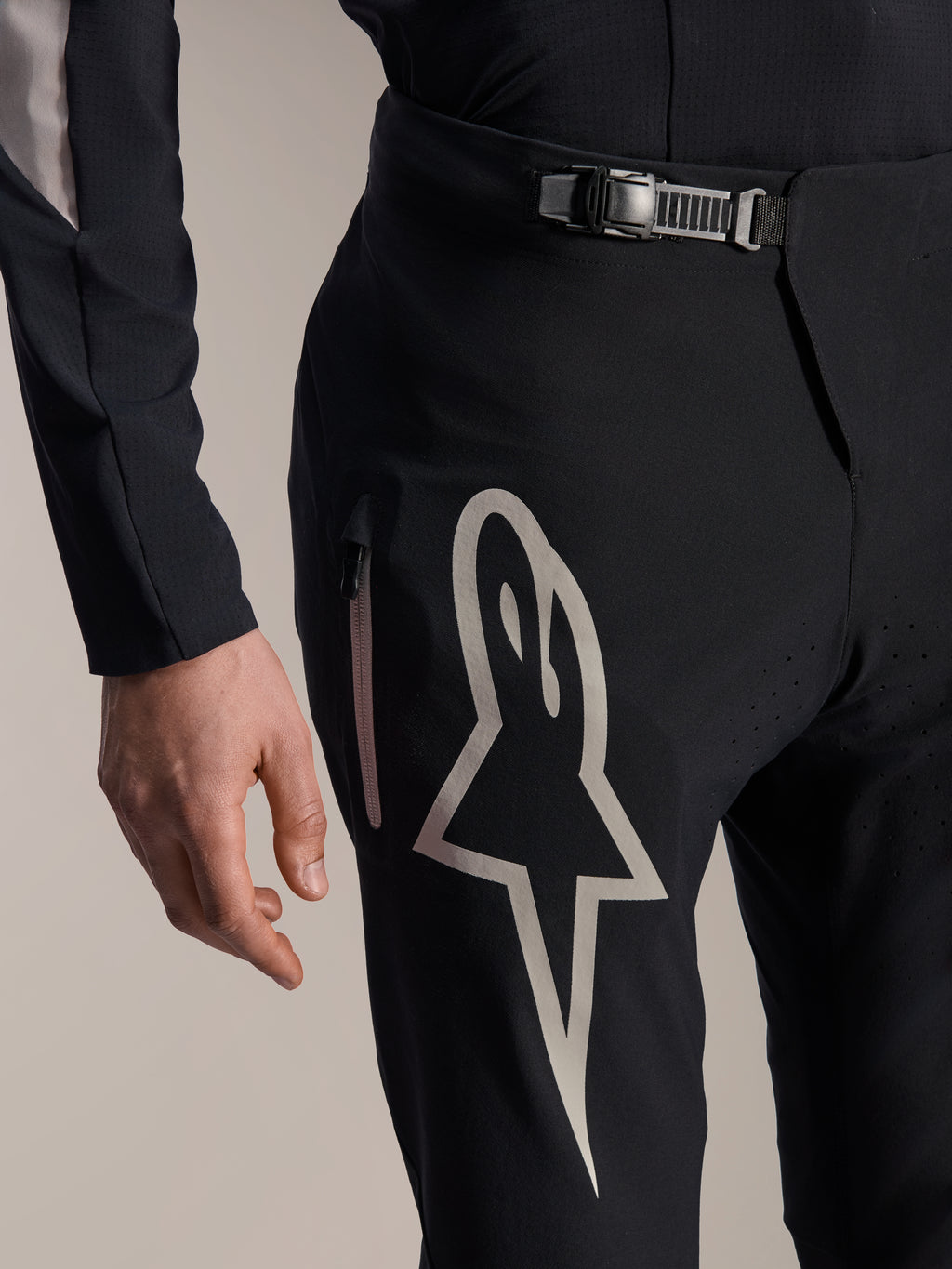 Alpinestars A-Supra Melt Pants, pantalones para bicicleta de montaña, negros, con un gran logotipo Astar blanco en el muslo, cierre de cintura ajustable con trinquete y bolsillo lateral con cremallera, vista detallada de equipamiento técnico de alto rendimiento para MTB