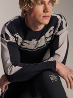 Jersey Alpinestars A-Supra Melt, jersey de MTB de manga larga, negro con gráficos en gris claro, usado por un modelo, con logotipo llamativo en el pecho y marca 'One Goal. One Vision.', ropa técnica de alto rendimiento para ciclismo de montaña