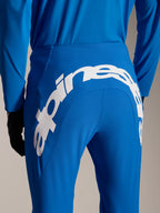 Pantalones y jersey Alpinestars A-Supra Melt, equipamiento de MTB en azul, vista trasera con un gran logotipo blanco de Alpinestars en el canesú trasero de los pantalones, jersey de manga larga a juego y guantes negros